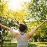 Healthy young Asian runner woman warm up the body stretching before exercise and yoga near lake at park under warm light morning. Lifestyle fitness and active women exercise in urban city concept.